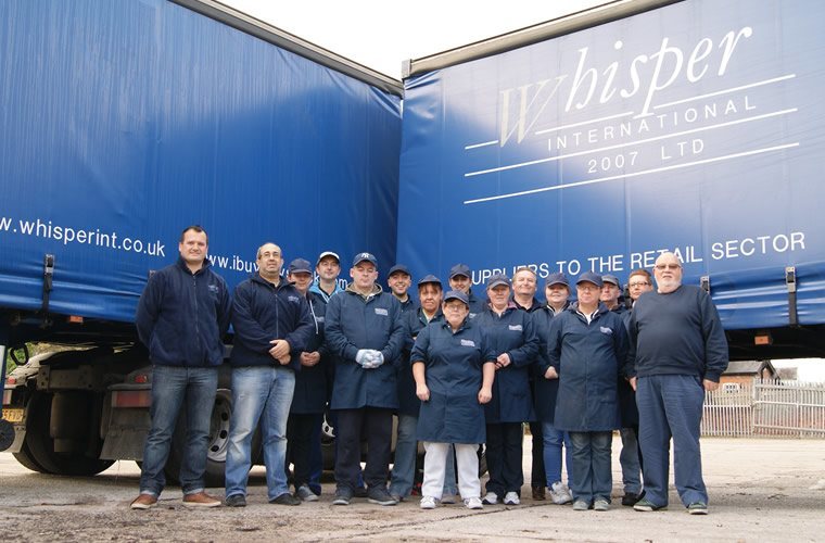 Whisper International team standing next to one of there trailers